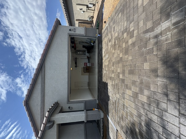 Freshly cleaned paver driveway in front of a Phoenix garage